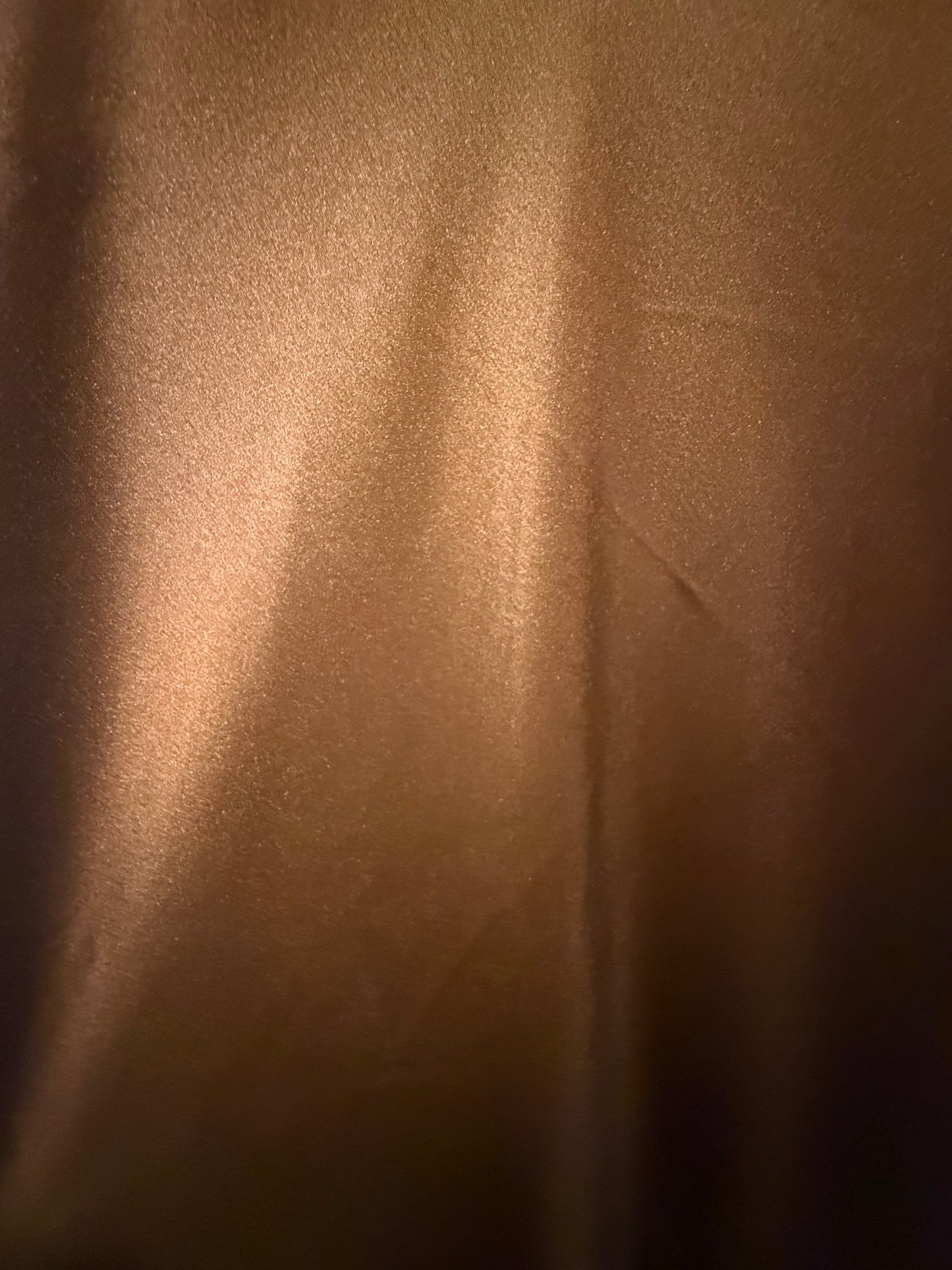 Close-up of luminous sienna copper fabric showing color variation in the light