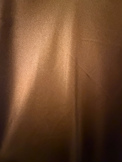 Close-up of luminous sienna copper fabric showing color variation in the light