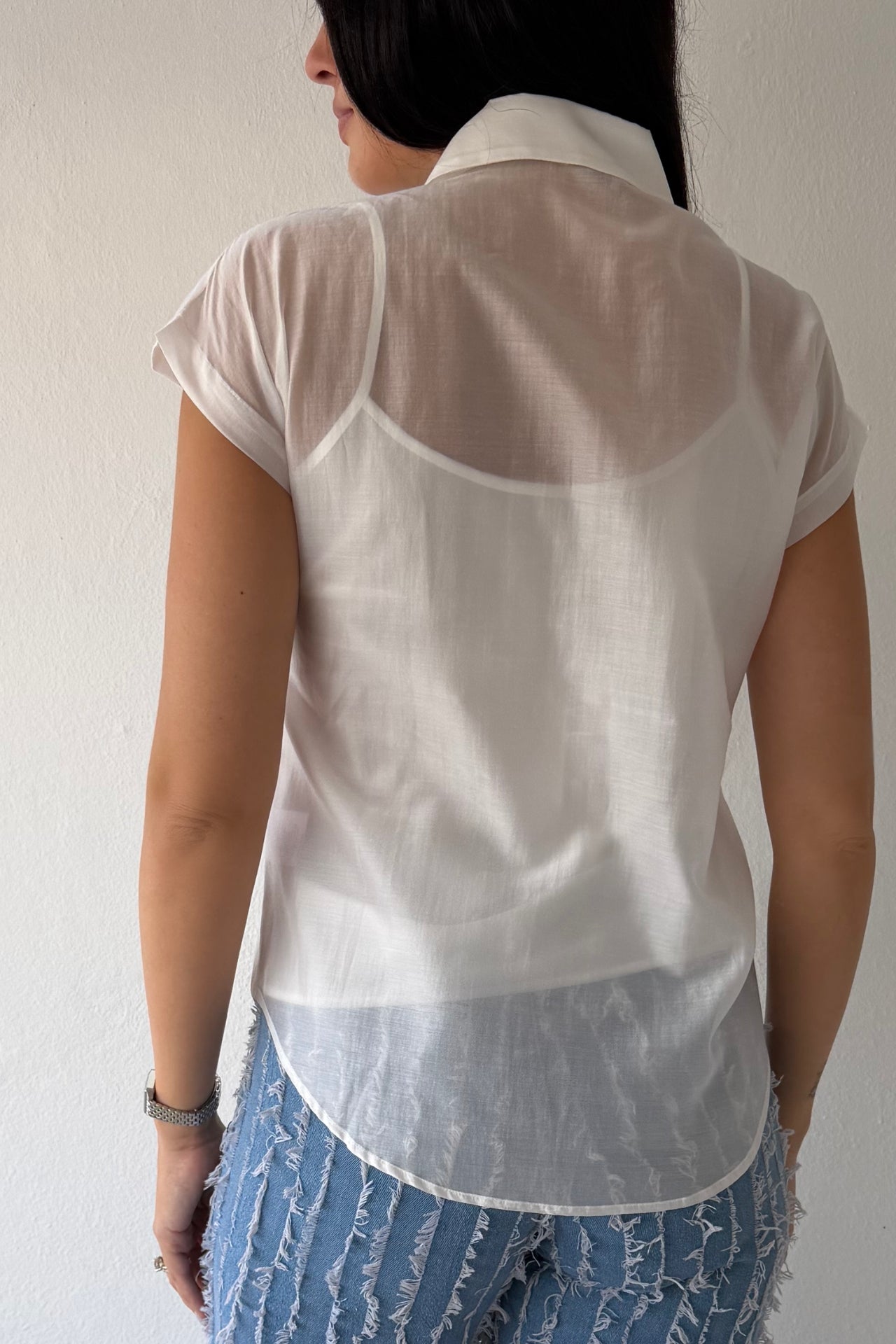 Model wearing the White Blossom Statement Blouse featuring three-dimensional floral appliqué details, short sleeves, and a coordinating camisole.