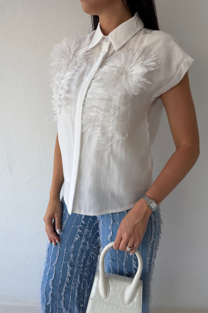 Model wearing the White Blossom Statement Blouse featuring three-dimensional floral appliqué details, short sleeves, and a coordinating camisole.