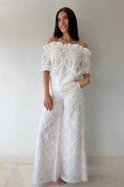 Model wearing the White Romance Set featuring an off-the-shoulder embroidered top and matching wide-leg pants in white cotton.
