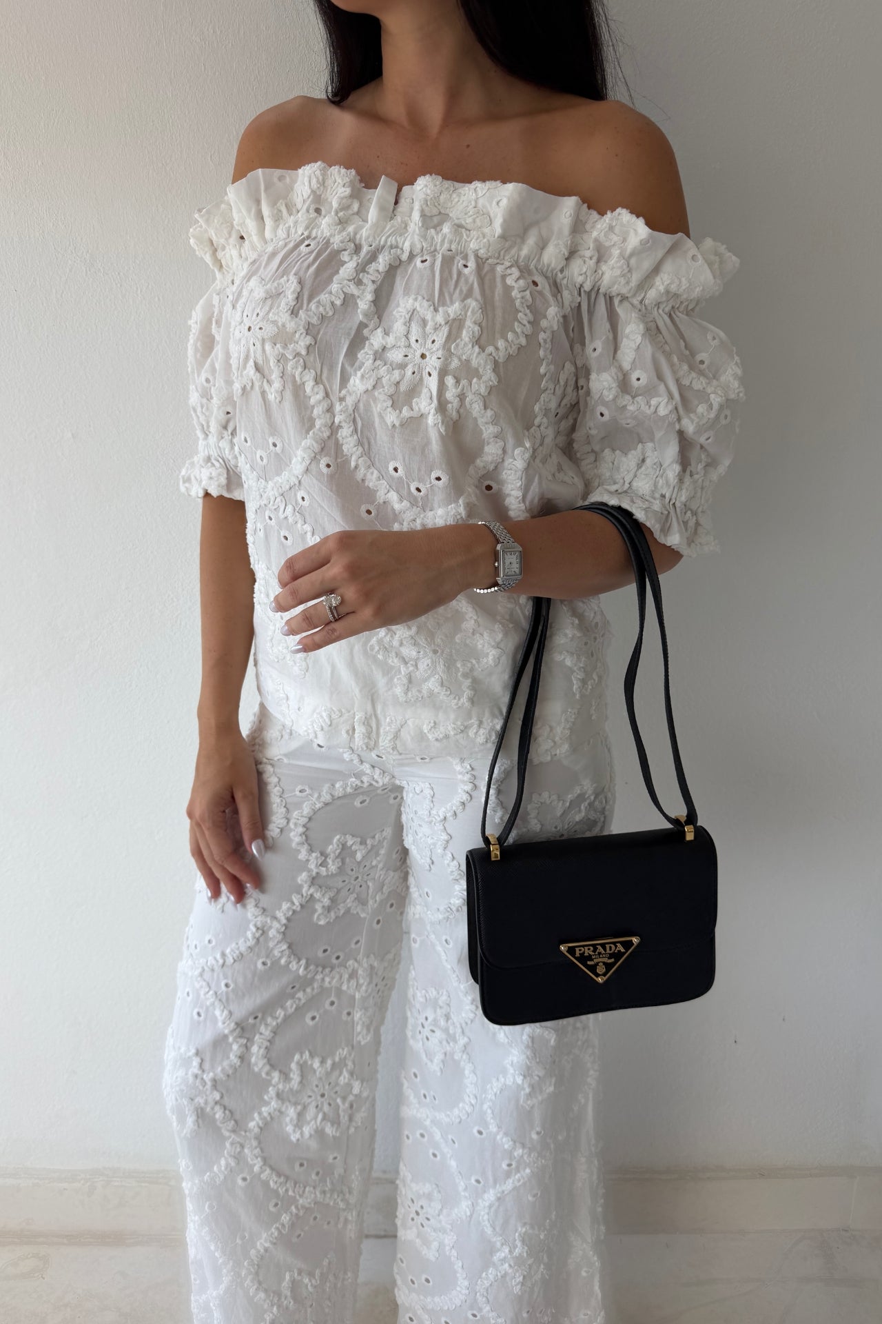 Model wearing the White Romance Set featuring an off-the-shoulder embroidered top and matching wide-leg pants in white cotton.