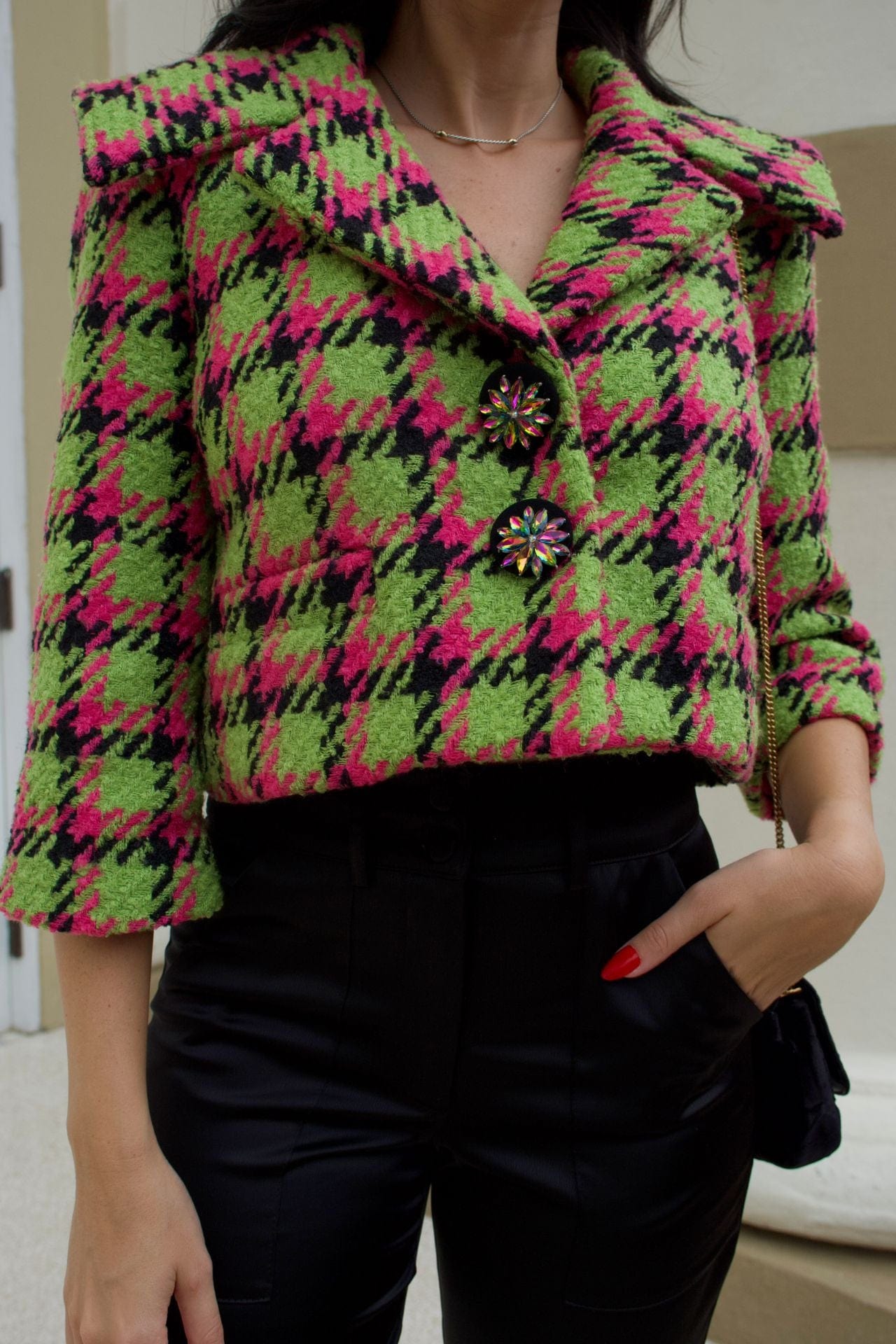 Close-up of apple green and magenta houndstooth cropped jacket with crystal buttons and wide collar.