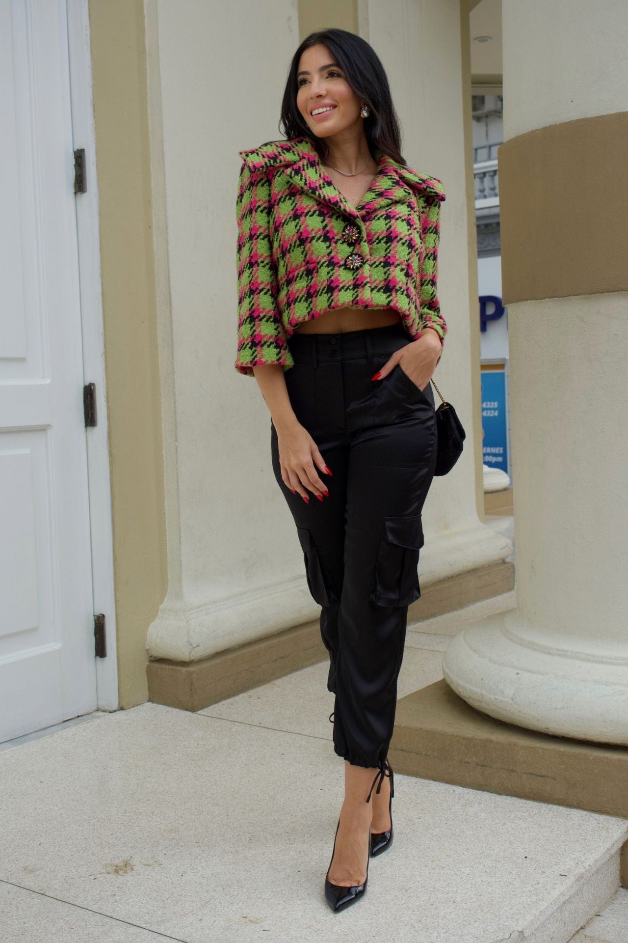 Close-up of apple green and magenta houndstooth cropped jacket with crystal buttons and wide collar.