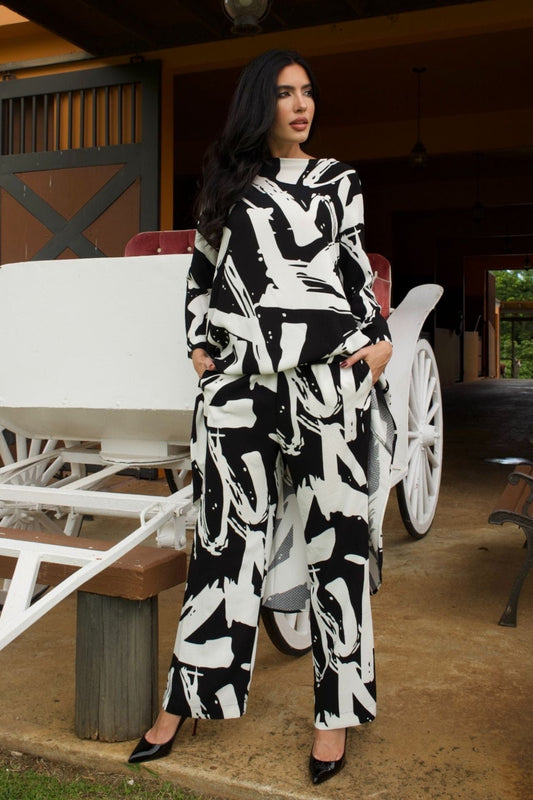 Woman wearing black and white abstract print high-low tunic set with matching wide-leg pants-front view

