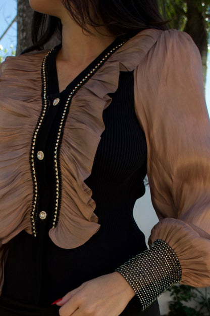 Closeup of a black blouse with champagne satin ruffle front and satin balloon sleeves with crystal cuffs — Elegance Boutique