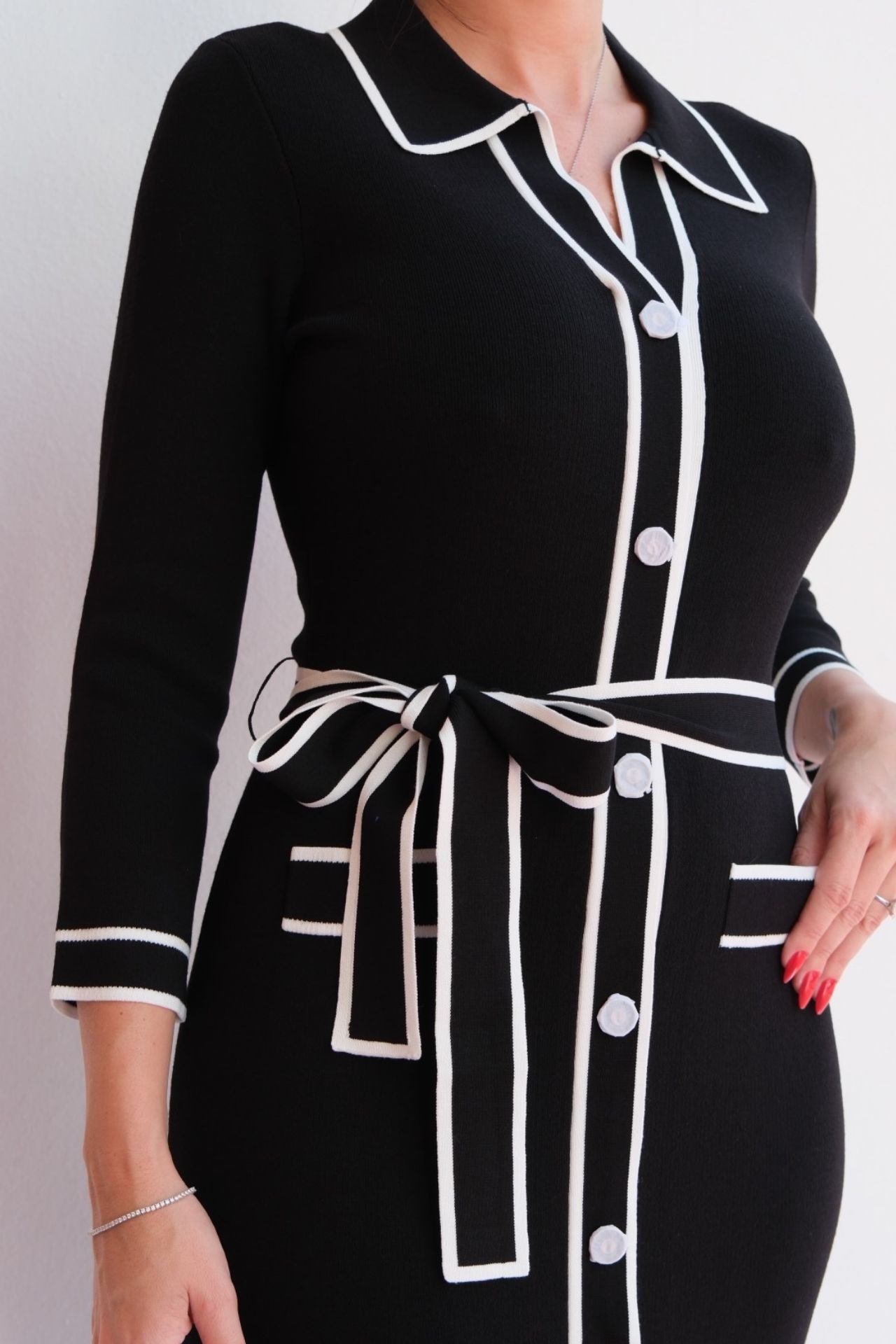 Black midi shirt dress with white contrast trim, button front, and waist tie, styled for an elegant day-to-night look