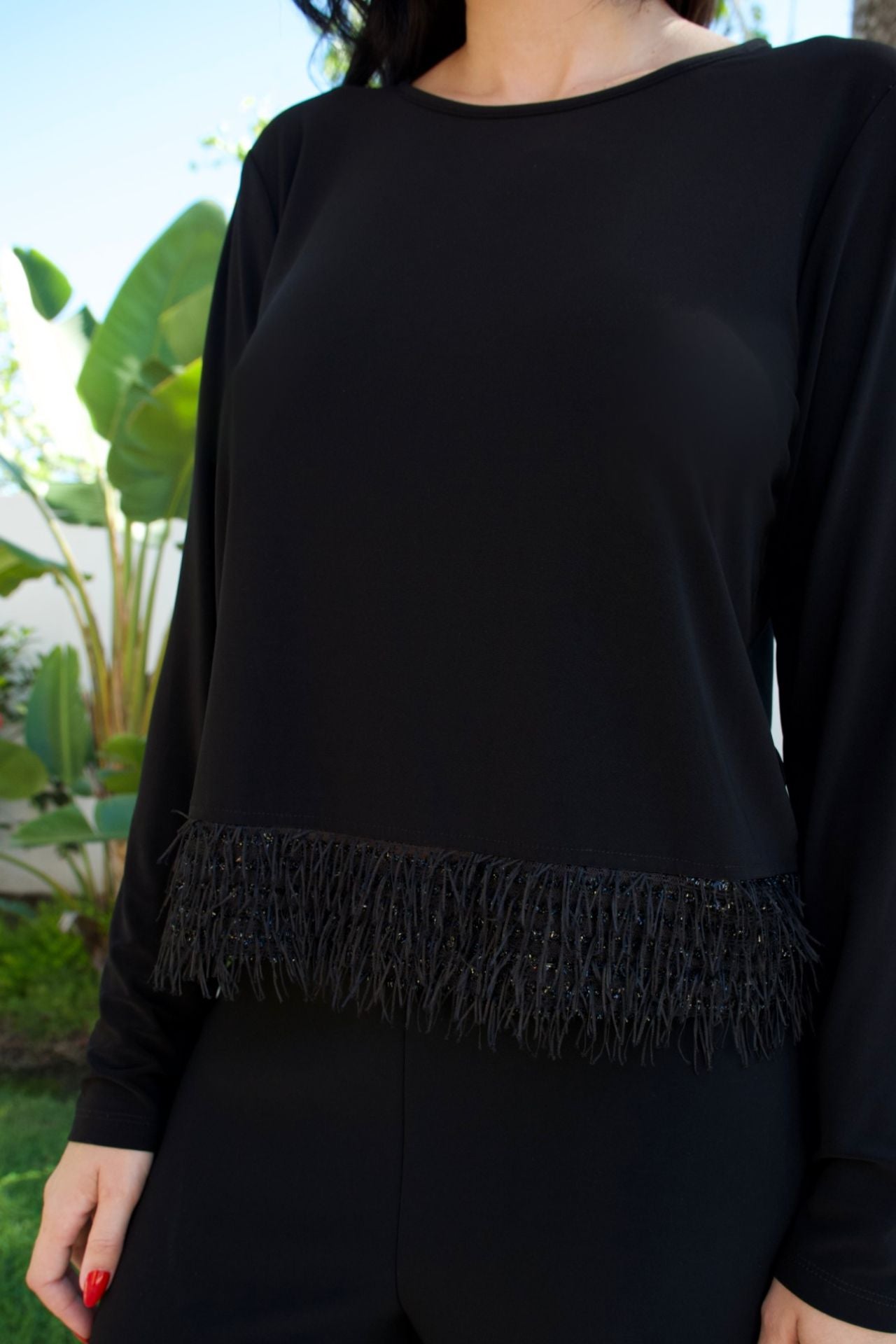 Model wearing black jersey fringe top and pant set with long sleeves — chic matching set Elegance Boutique
