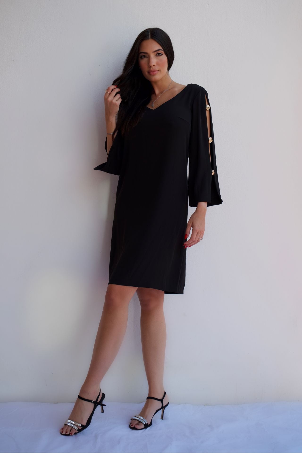 Black V-neck shift dress with gold button sleeve detail, elegant wrinkle-resistant cocktail dress for women.