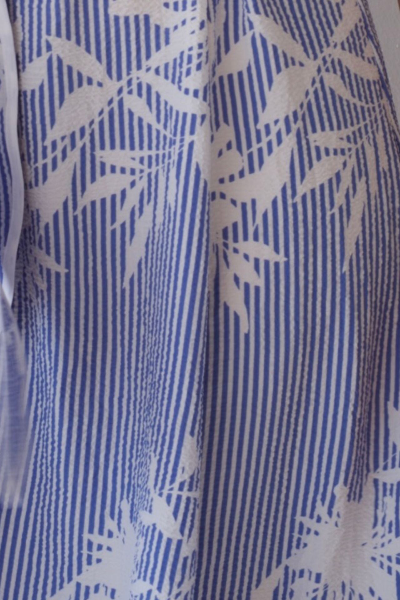 Close-up of a blue and white patterned fabric with leaf design.