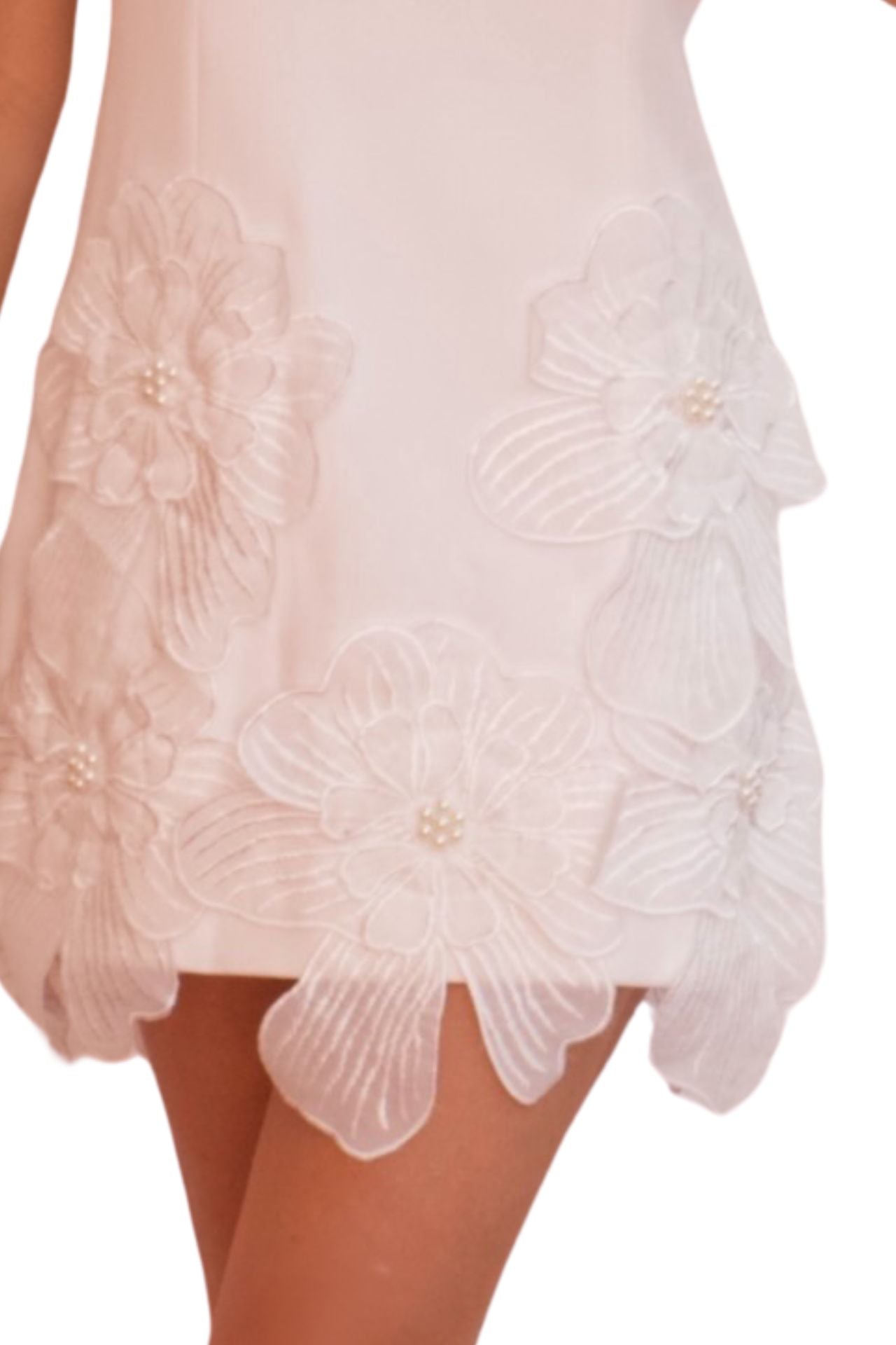 White cocktail dress with 3D floral appliqué and scalloped hem, elegant sleeveless mini dress for special occasions.