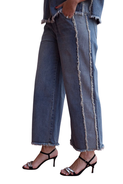 Woman wearing a two-piece denim set with frayed hem shirt and wide-leg cropped pants.