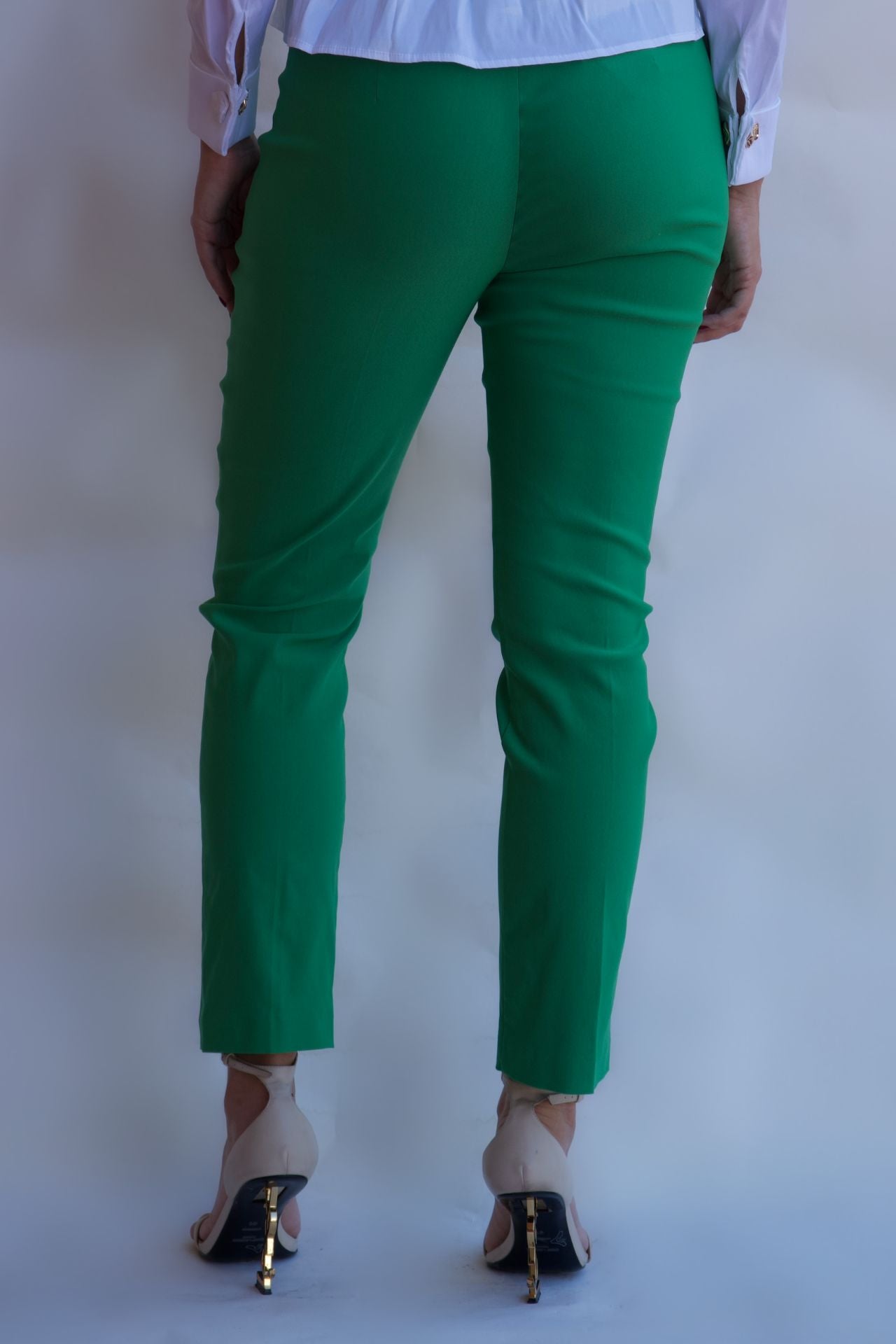 Emerald green tailored pull on pants with front pockets and silver buttons styled with white blouse available online and in-store