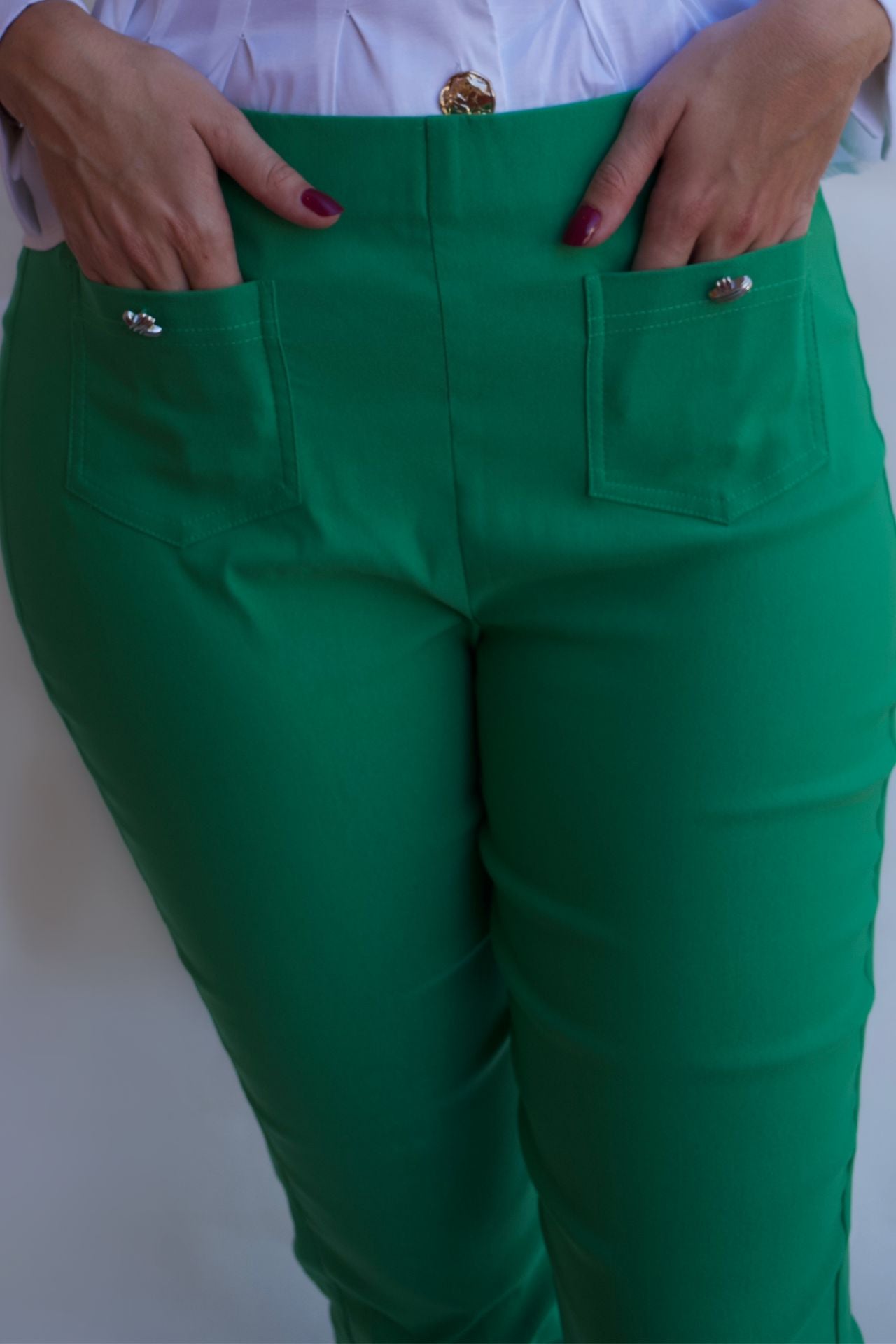 Emerald green tailored pull on pants with front pockets and silver buttons styled with white blouse available online and in-store