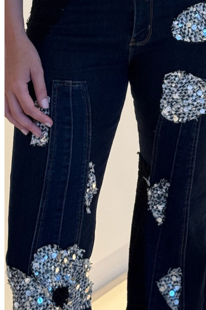 Dark wash wide-leg denim with floral sequin appliqué patches and high-rise fit.