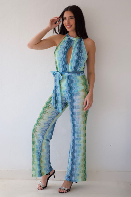 Woman wearing a blue and green patterned jumpsuit against a white background