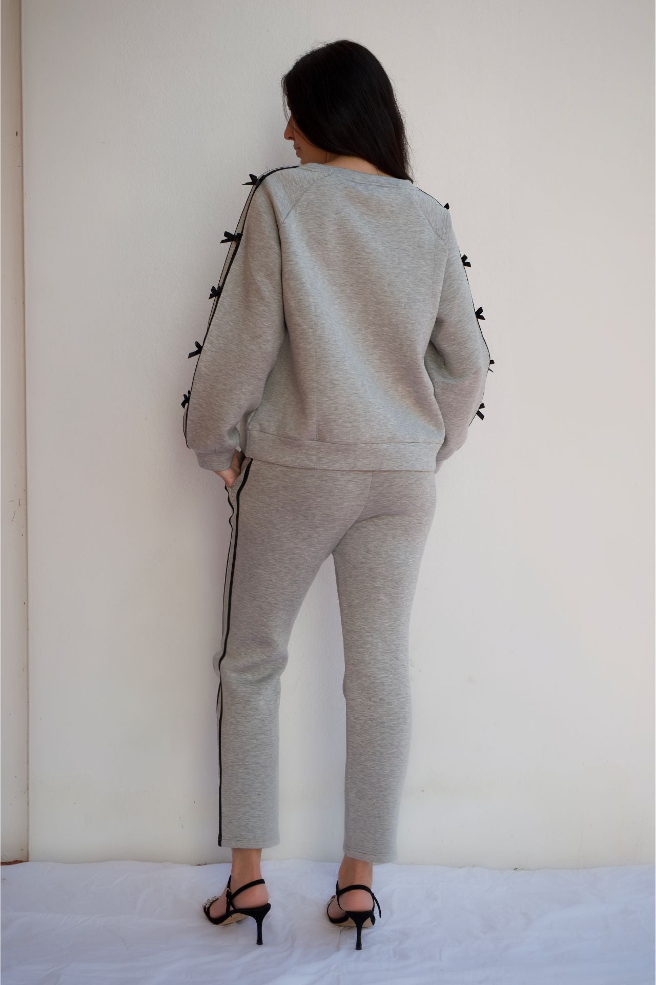 Woman wearing grey and black knit travel set with relaxed sweater and pull-on pants styled for casual chic loungewear