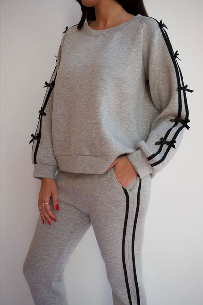 Woman wearing grey and black knit travel set with relaxed sweater and pull-on pants styled for casual chic loungewear