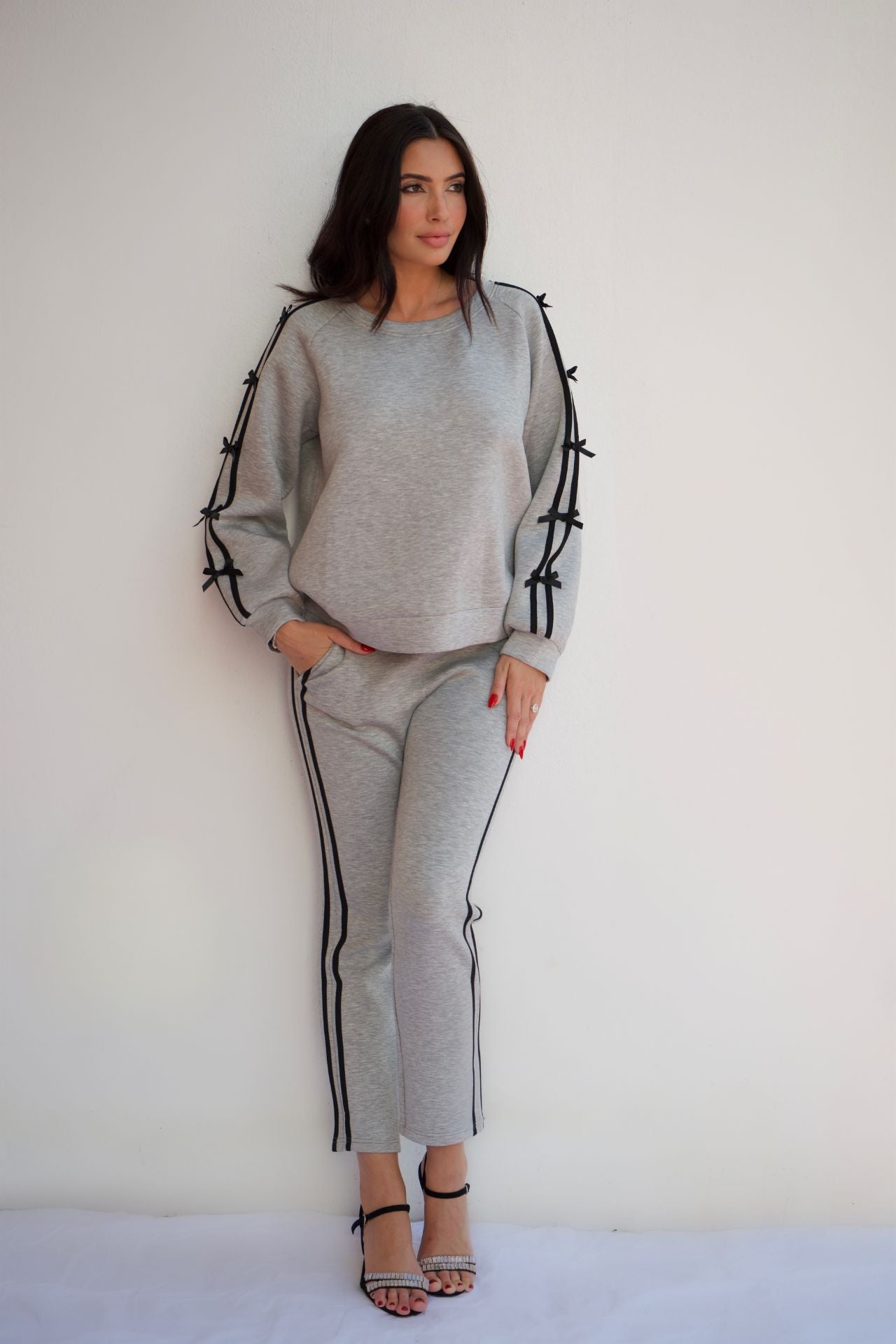 Woman wearing grey and black knit travel set with relaxed sweater and pull-on pants styled for casual chic loungewear