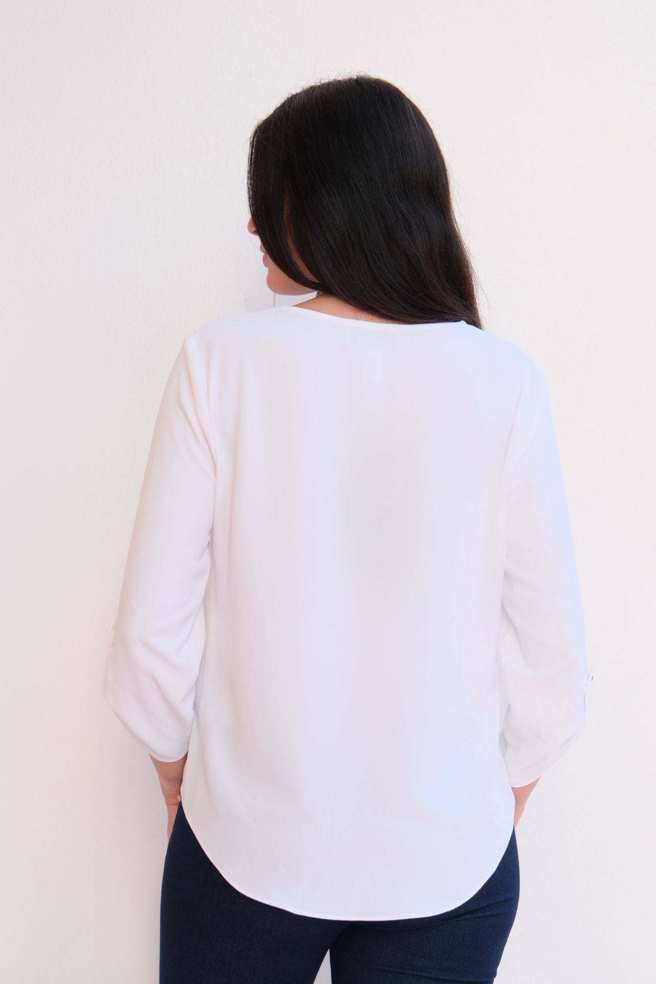 white flow blouse with jewel button neckline detail and relaxed fit styled with dark denim