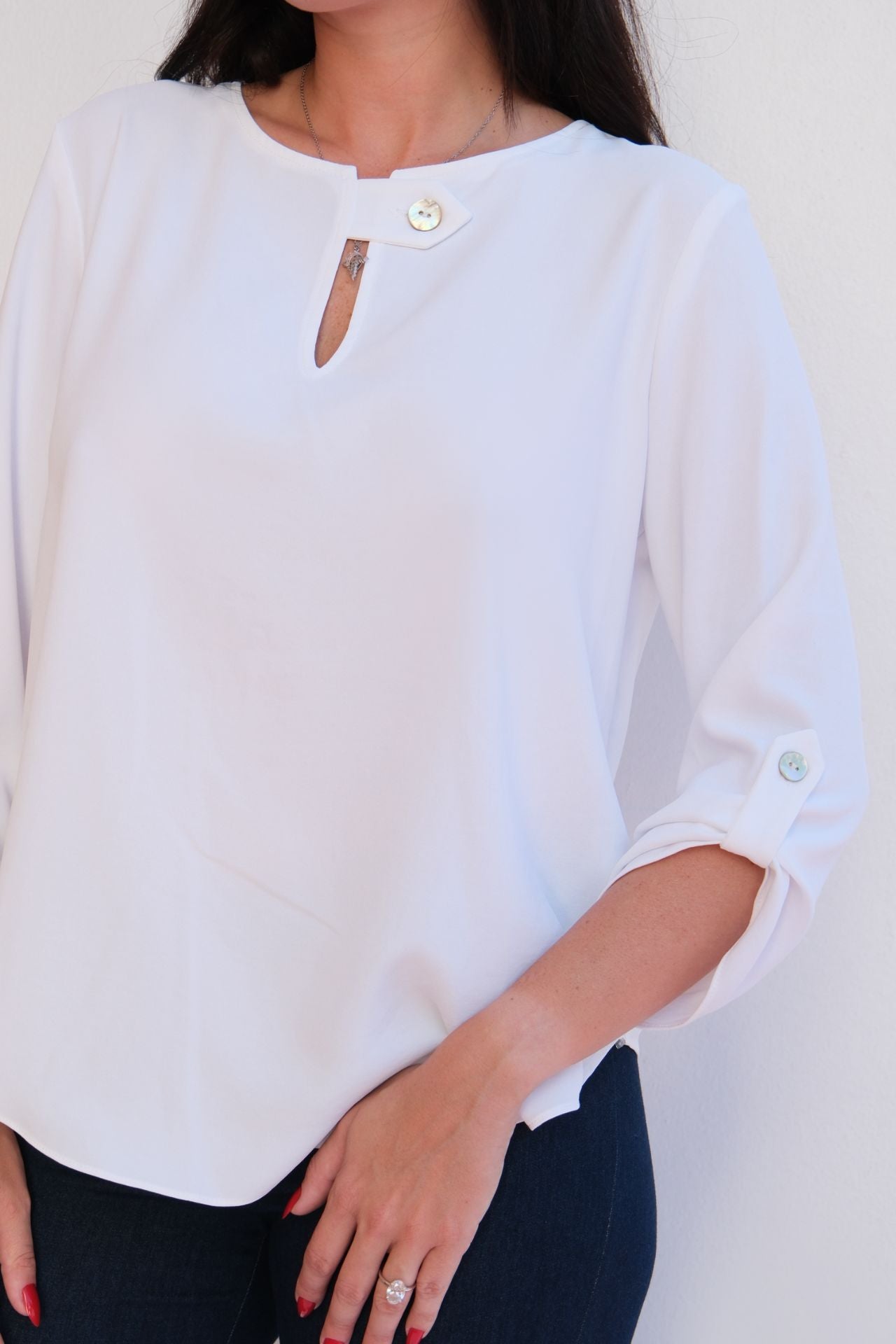 white flow blouse with jewel button neckline detail and relaxed fit styled with dark denim