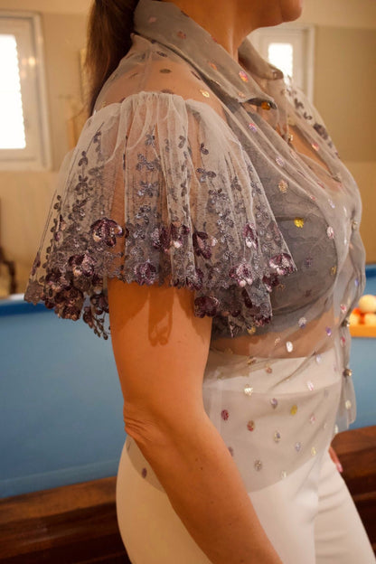 Close-up detail of Metallic Mesh Bell Sleeve Blouse - rhinestone button and embroidered mesh texture.

