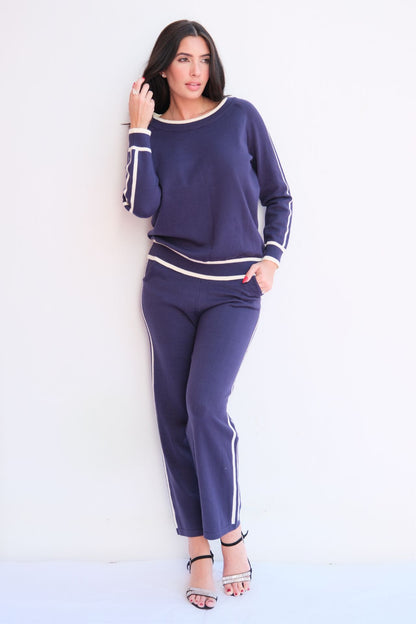 Woman wearing navy knit lounge set with white stripes. 