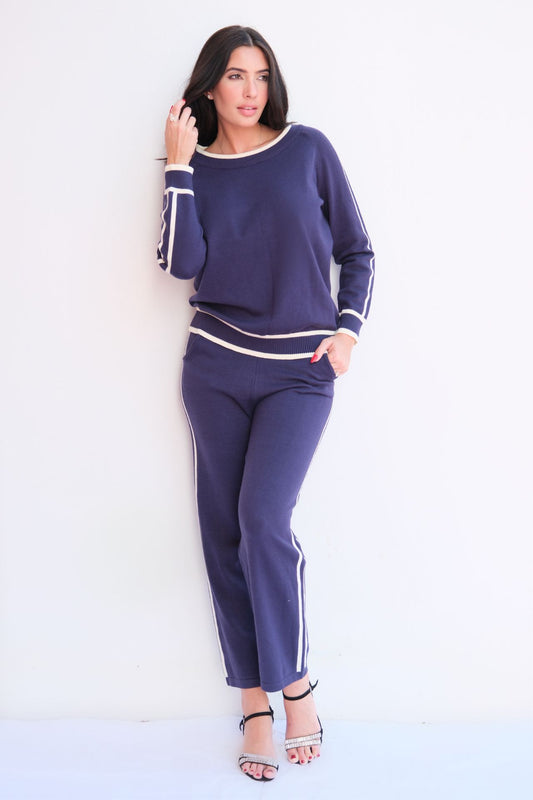 Woman wearing navy knit lounge set with white stripes. 