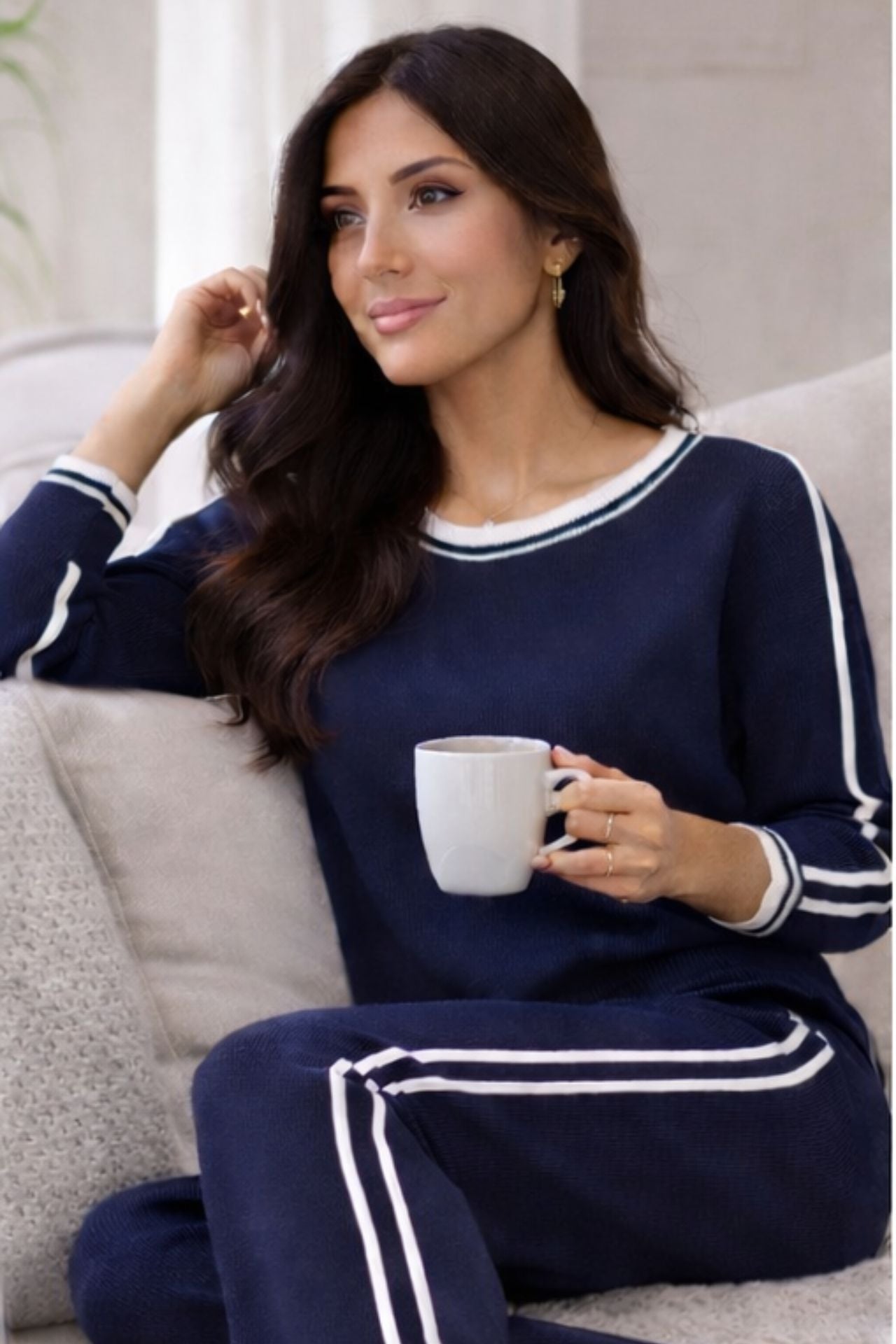 Woman wearing navy knit lounge set with white stripes. 