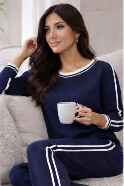 Woman wearing navy knit lounge set with white stripes. 
