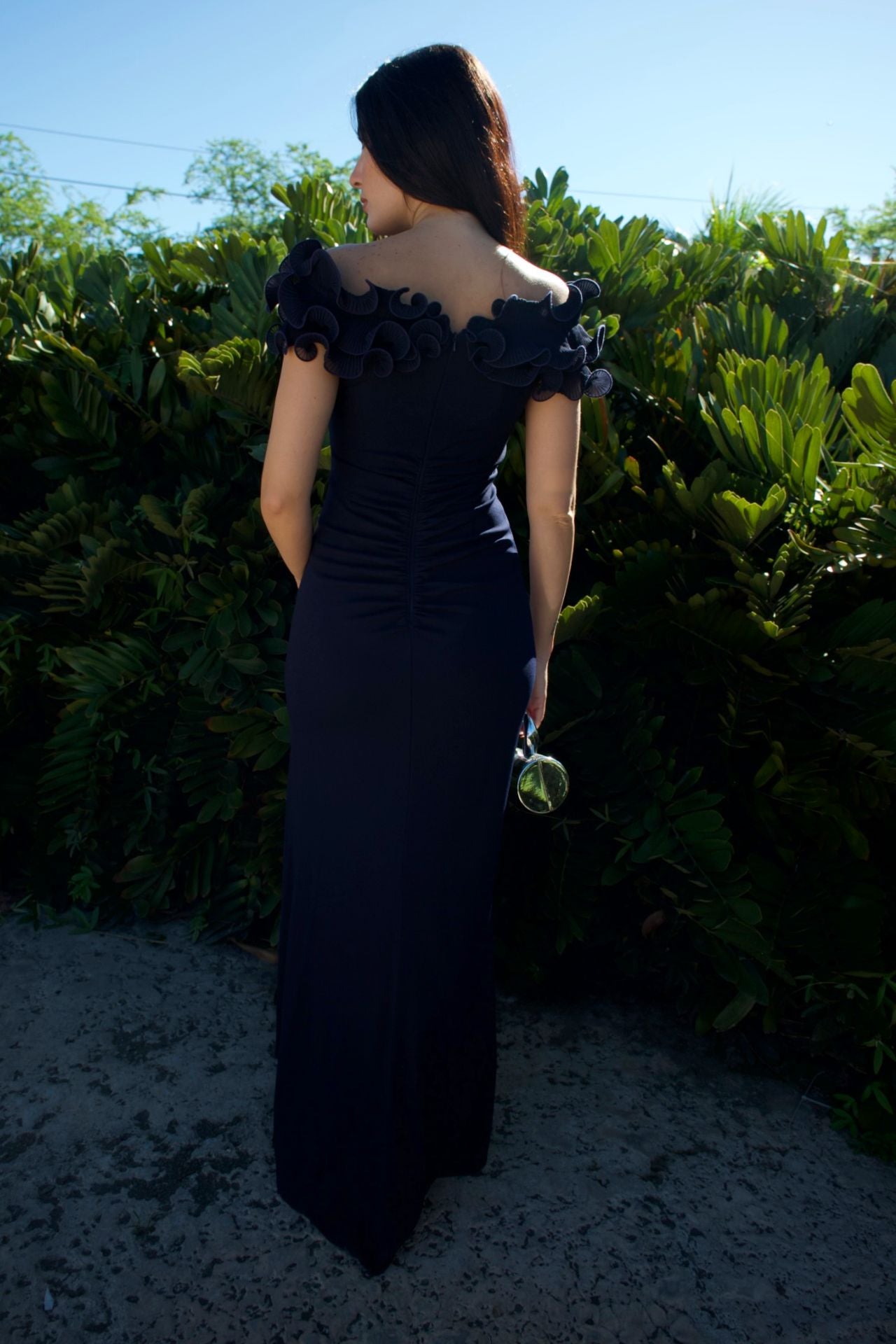 Model wearing navy evening gown with sculpted ruffle bodice and front slit — formal wear Elegance Boutique