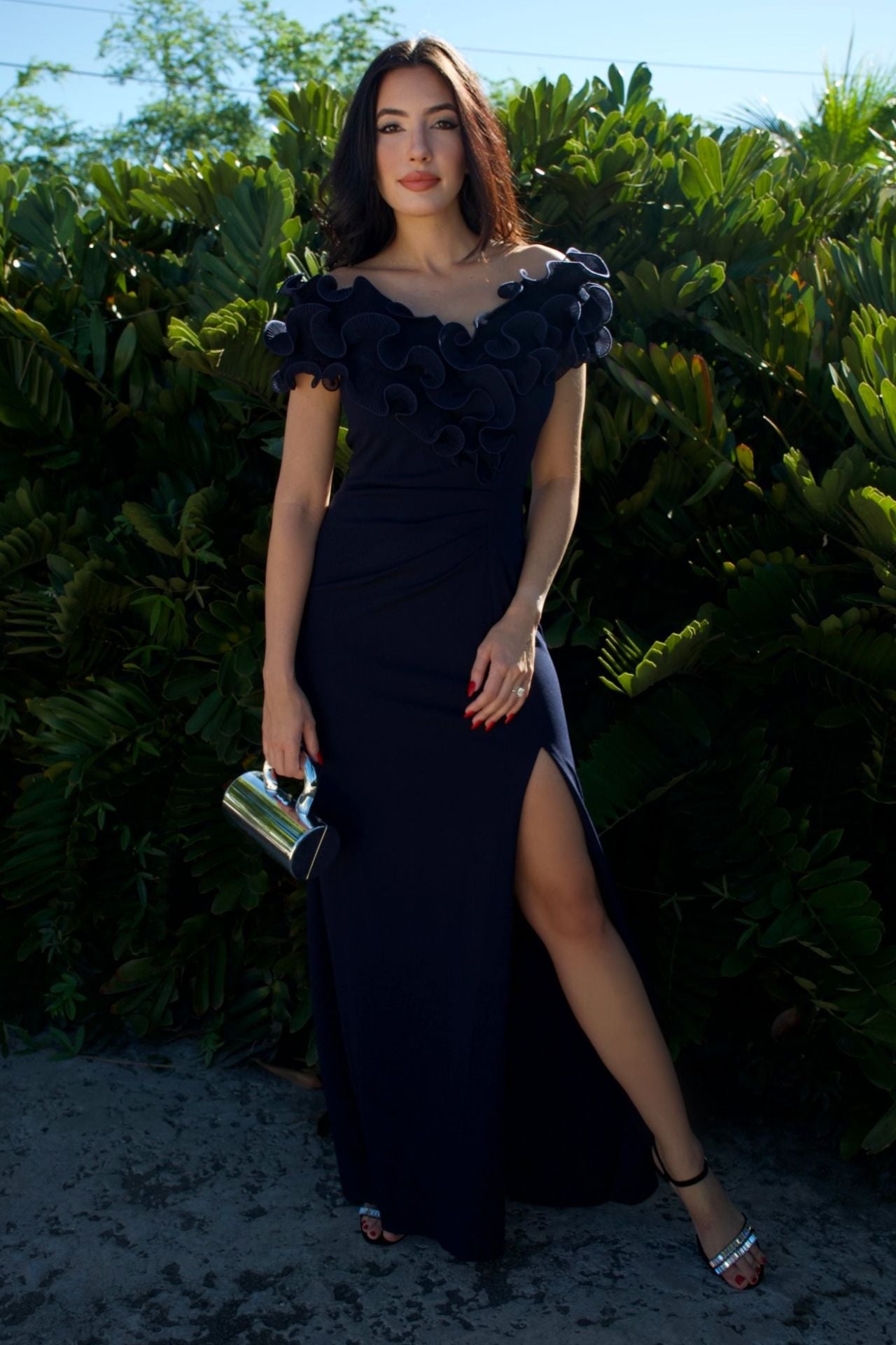 Model wearing navy evening gown with sculpted ruffle bodice and front slit — formal wear Elegance Boutique