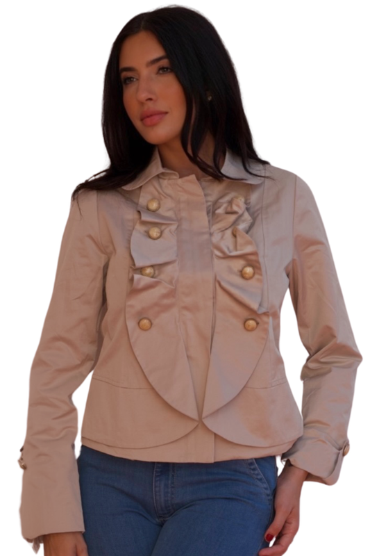 Model wearing a beige structured jacket with gold button detail and feminine tailored silhouette.