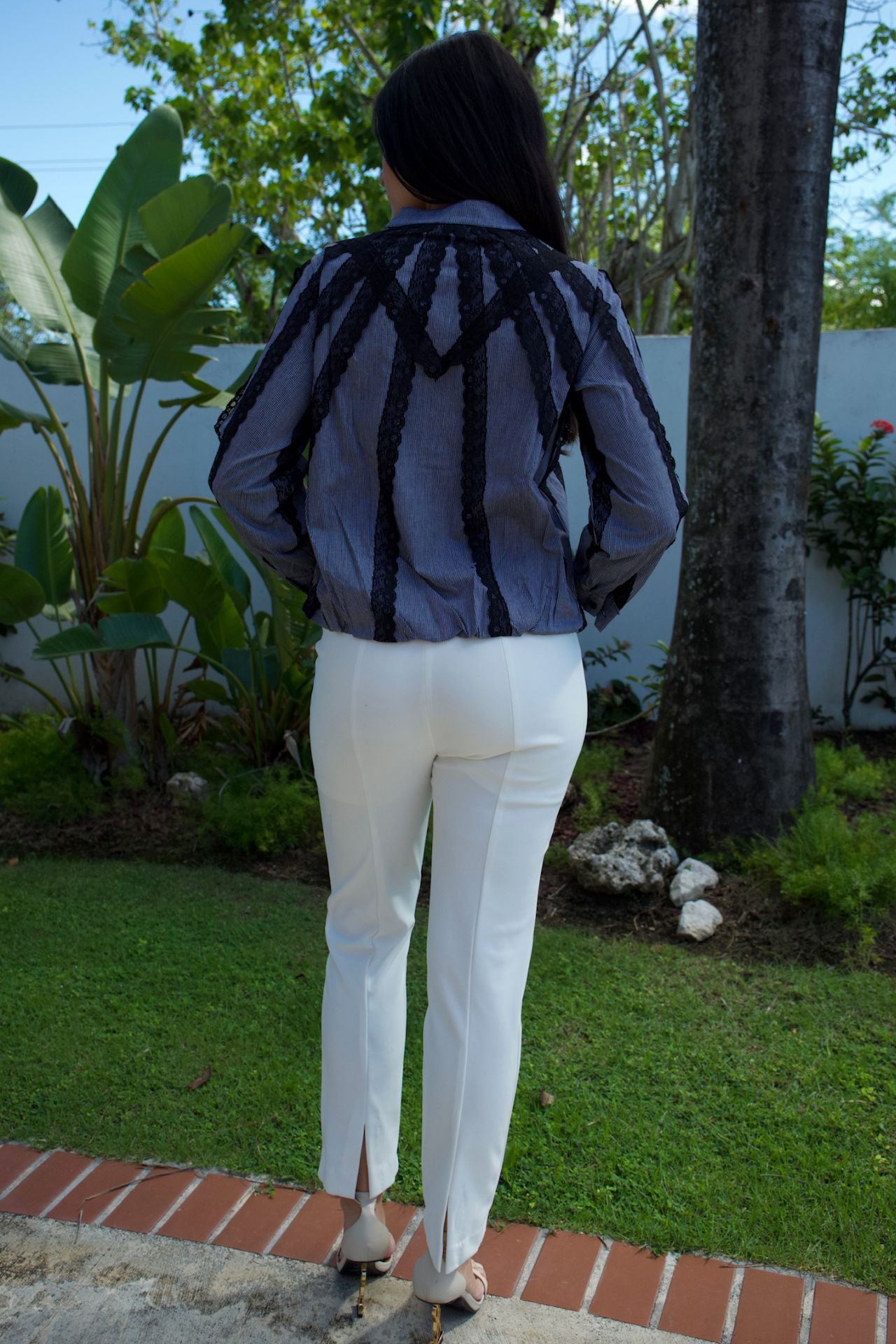 Model wearing grey pinstripe blouse with black lace trim — chic daytime look Elegance Boutique