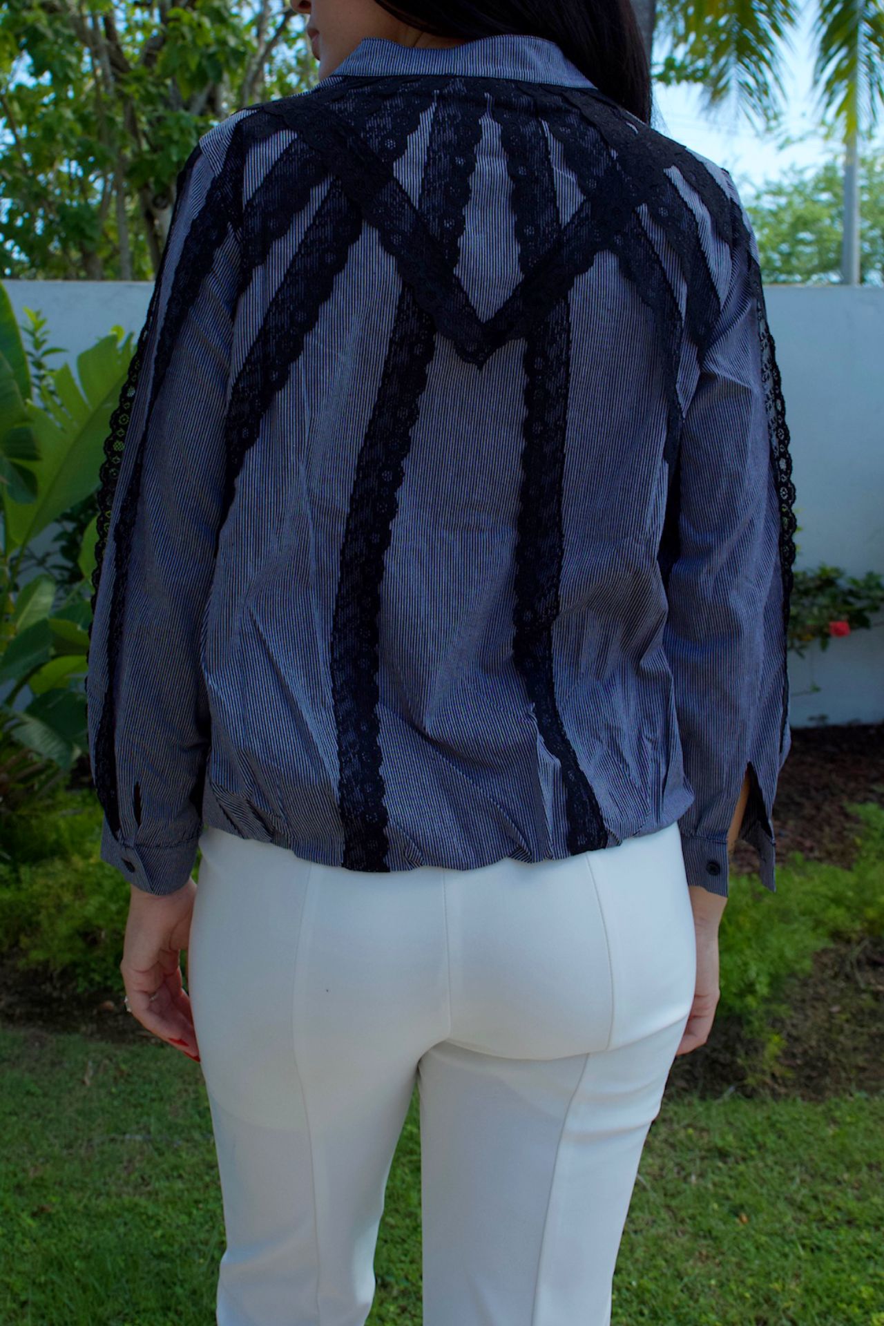 Model wearing grey pinstripe blouse with black lace trim — chic daytime look Elegance Boutique