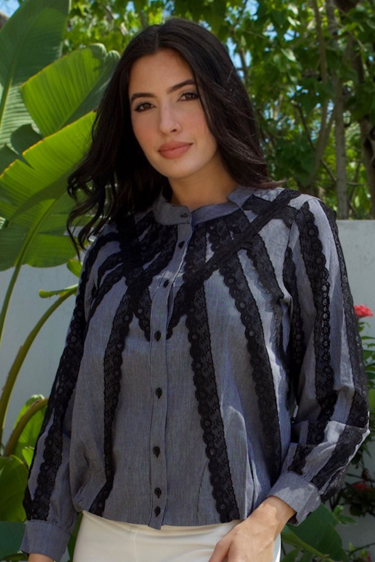 Model wearing grey pinstripe blouse with black lace trim — chic daytime look Elegance Boutique