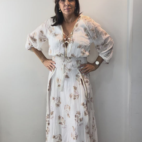 Model wearing Ivory Botanical Smocked Waist Maxi Dress with floral print and flattering smocked waist detail.