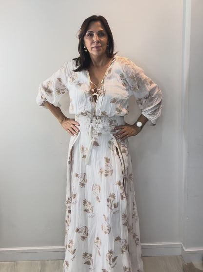 Model wearing Ivory Botanical Smocked Waist Maxi Dress with floral print and flattering smocked waist detail.