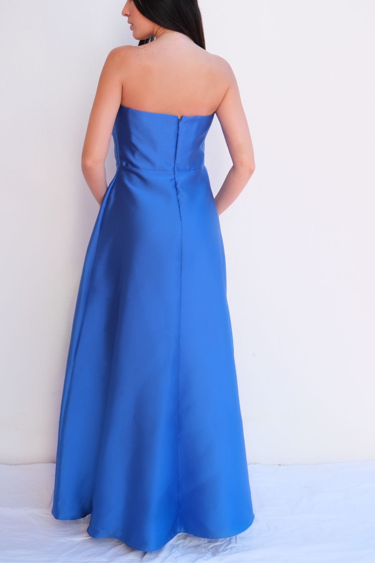 Royal blue satin strapless gown with oversized bow detail at bust and flowing A-line skirt styled for formal evening event