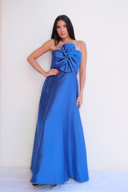 Royal blue satin strapless gown with oversized bow detail at bust and flowing A-line skirt styled for formal evening event