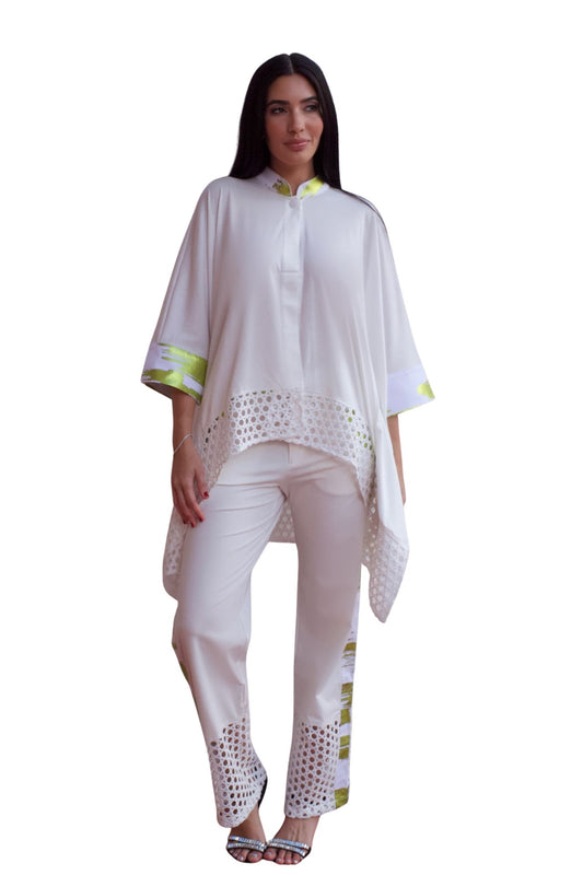 Woman wearing an elegant white eyelet detail pant set with relaxed high-low top and straight-leg pants.
