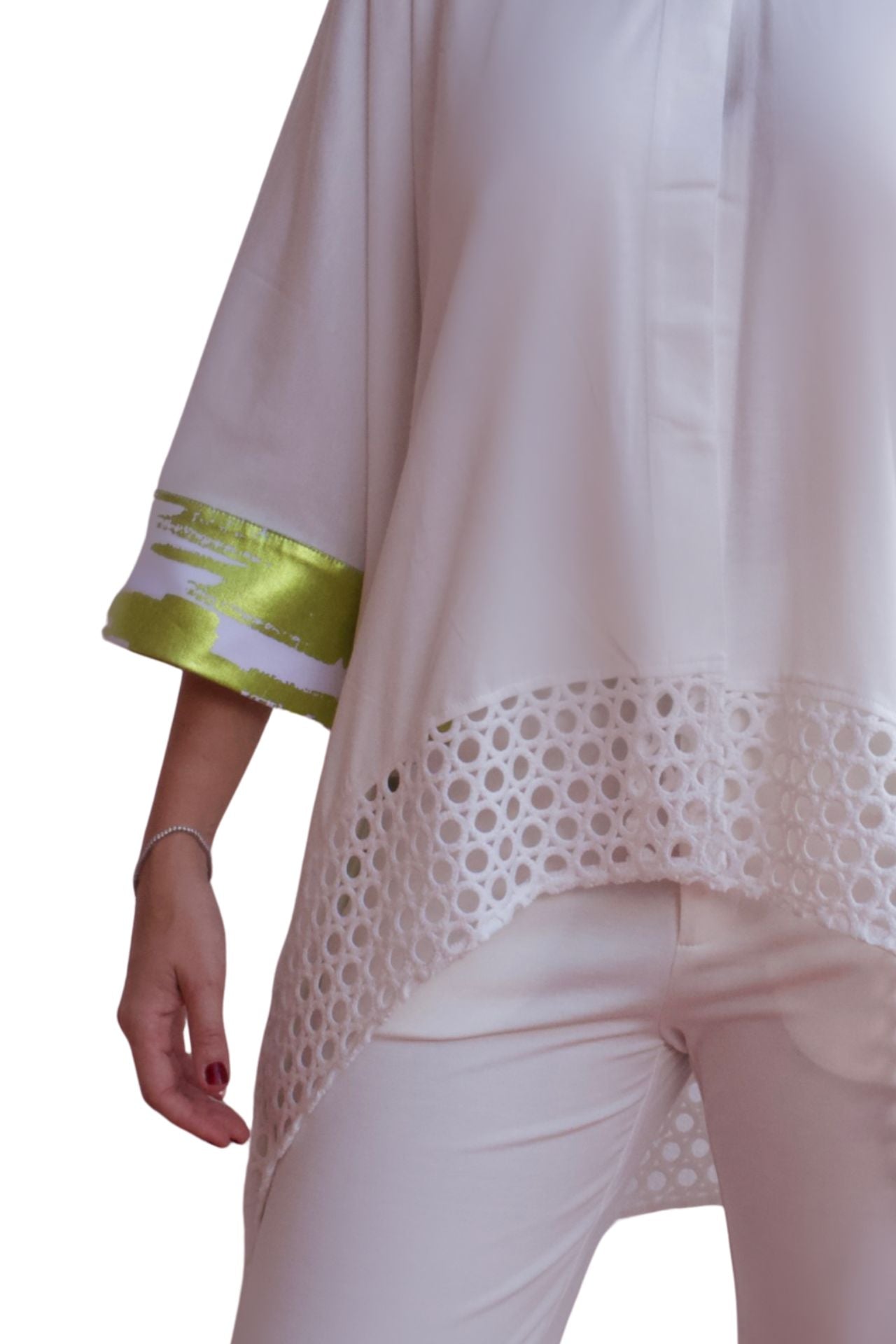 Woman wearing an elegant white eyelet detail pant set with relaxed high-low top and straight-leg pants.