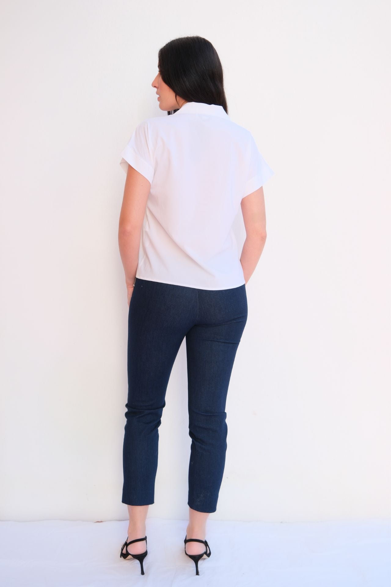 White modern zip blouse for women with gold zipper collar and short sleeves styled with dark jeans – chic casual elegant top