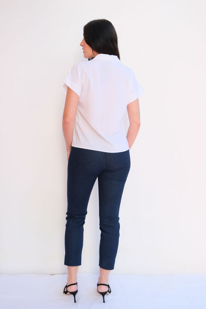 White modern zip blouse for women with gold zipper collar and short sleeves styled with dark jeans – chic casual elegant top