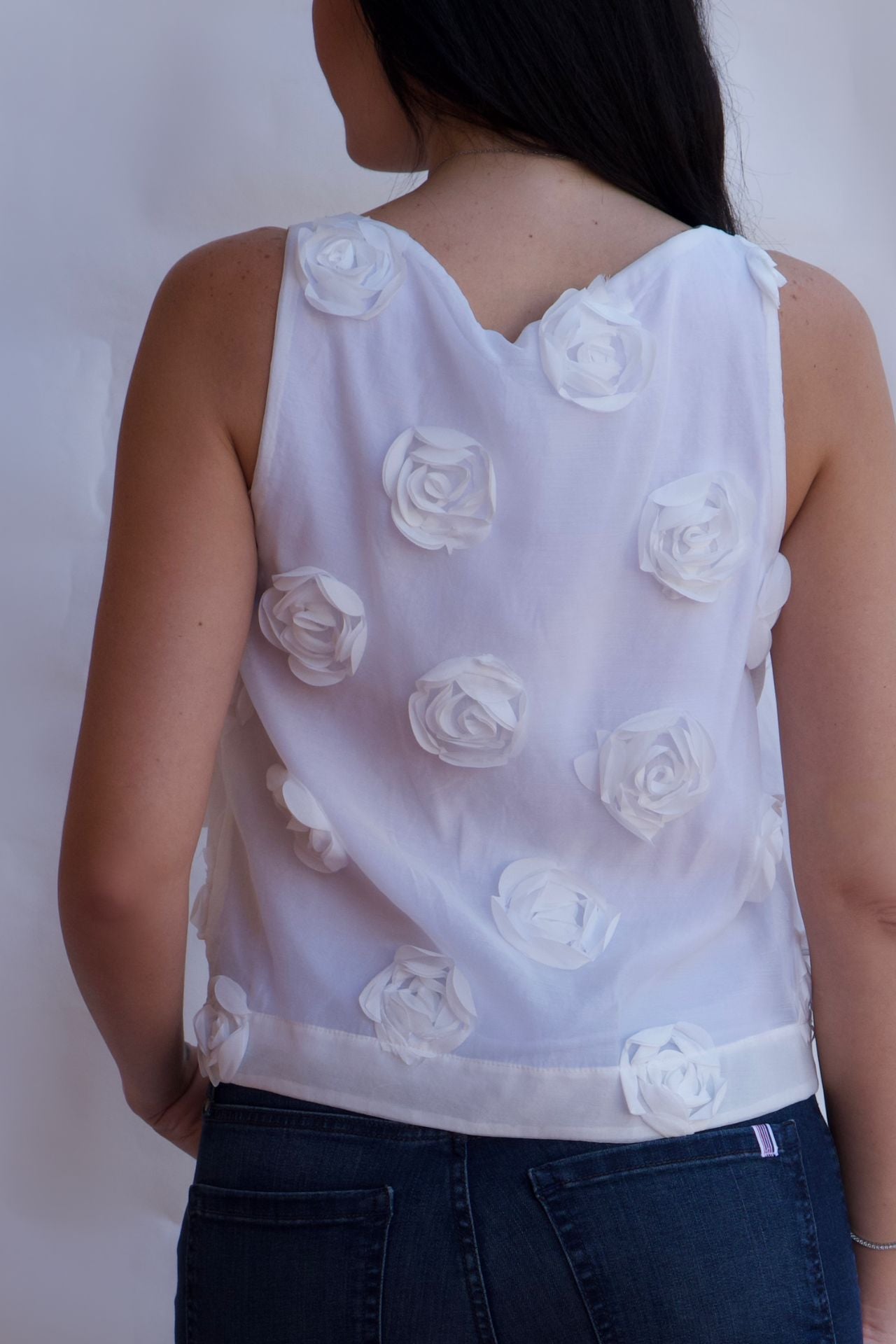 white rosette appliqué sleeveless textured blouse front view feminine statement top available online and in-store