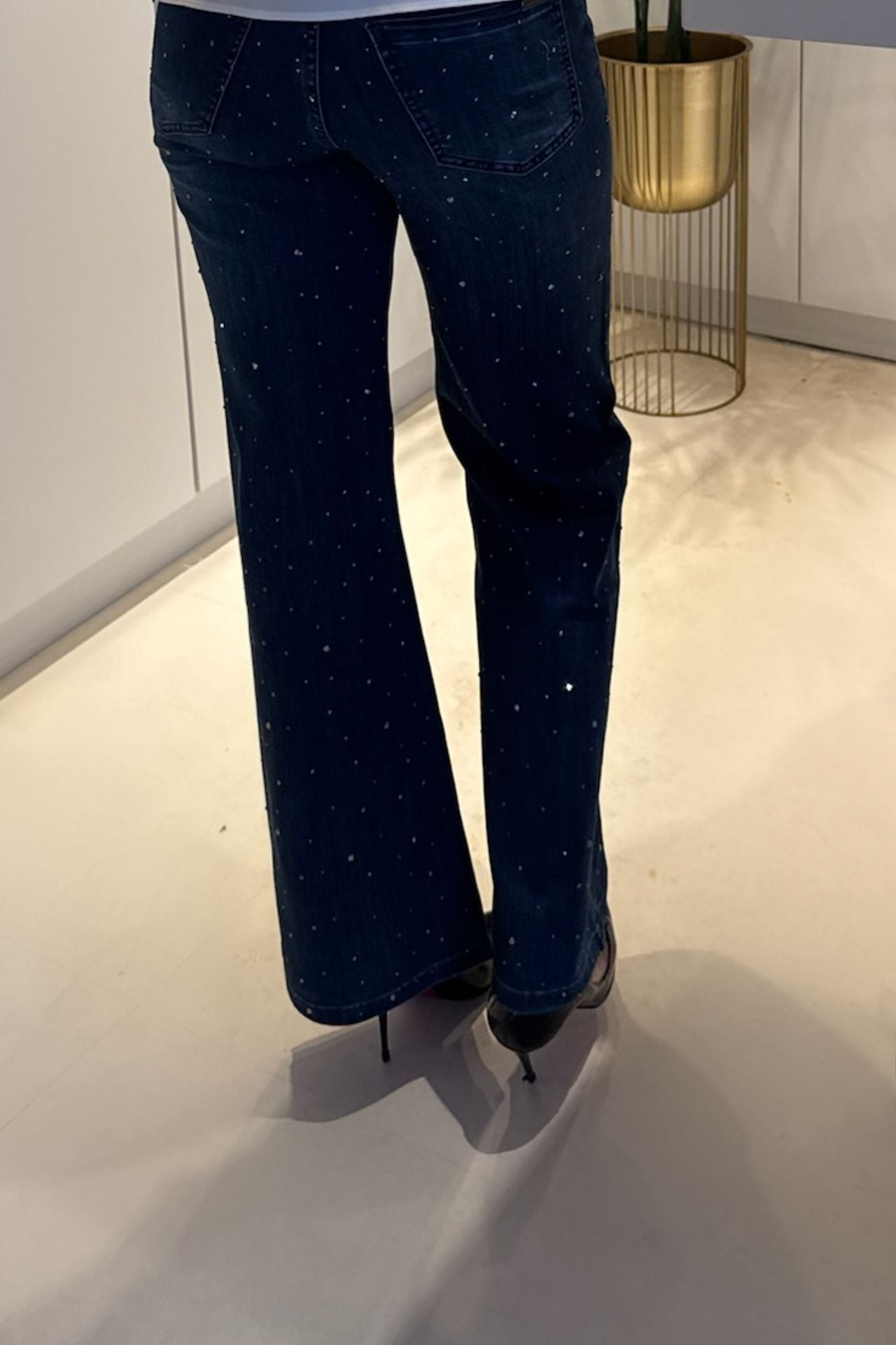 Back view of wide-leg dark denim jeans with scattered crystal stud embellishments