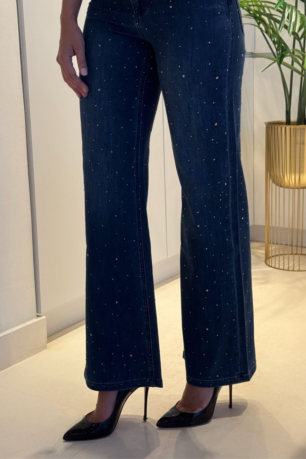 Navy blue pants with silver speckles worn by a person indoors.